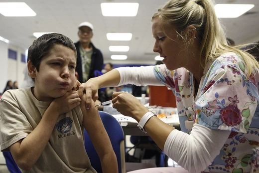 A nurse administers the H1N1 vaccine to ten-year-old Anthony Adams in Haltom City, Texas, in October 2009.