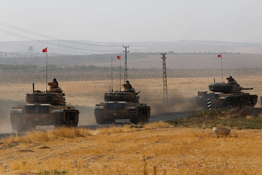 Turkish tanks drive towards the Turkish-Syrian border.