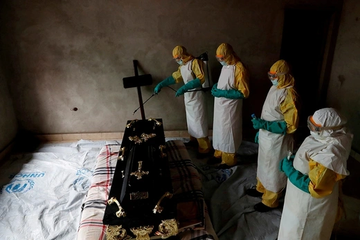 A health-care worker sprays a room during the funeral of a suspected Ebola victim in Beni, Democratic Republic of Congo, in December 2018.
