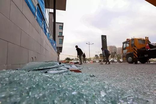 A man sweeps up broken glass outside a shop in Erbil, Iraq after a rocket attack.