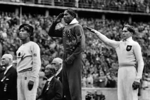 During the awards ceremony, U.S. athlete Jesse Owens salutes next to Nazi Germany's Lutz Long, who does the Nazi salute.