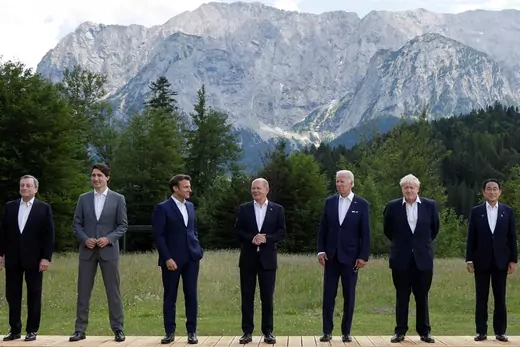 The leaders of the Group of Seven members stand against a forested and mountainous backdrop.