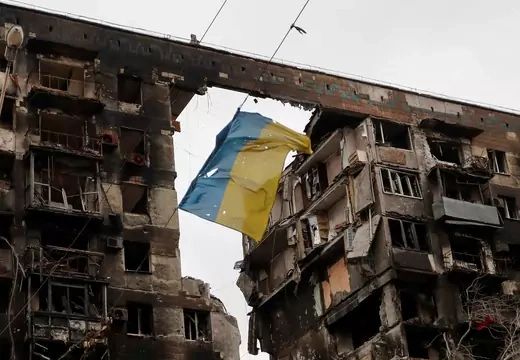 A view shows a torn flag of Ukraine hung on a wire in front an apartment building destroyed in the southern port city of Mariupol, Ukraine, April 14. REUTERS/Alexander Ermochenko