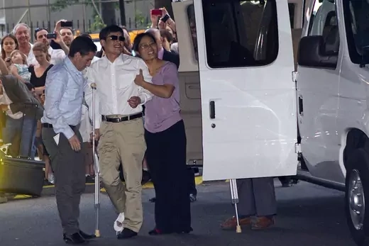 Chen, helped by his wife, arrives in New York.