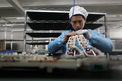 A worker inside an electronics factory in Qingdao.