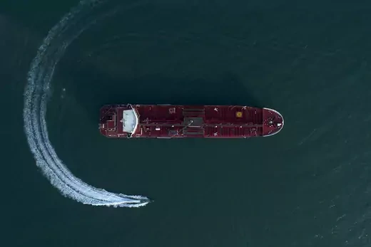 Aerial shot of a small boat circling a red tanker