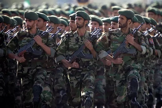 Members of the Iranian Revolutionary Guard Corps hold guns while marching in a parade