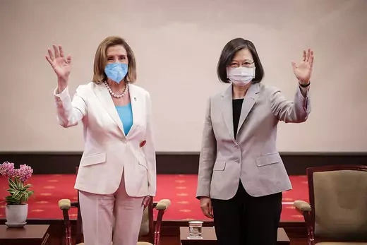 Nancy Pelosi and Tsai Ing-wen stand next to each other and wave to the camera. 
