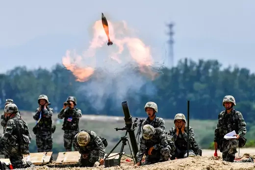 Chinese soldiers fire a weapon.