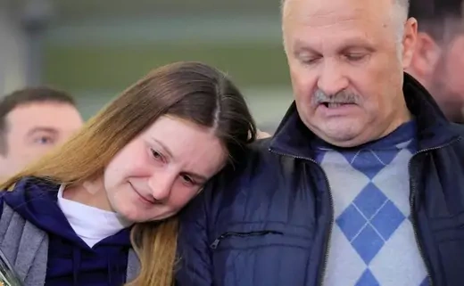 Maria Butina leans on the shoulder of her father, Valery Butin.
