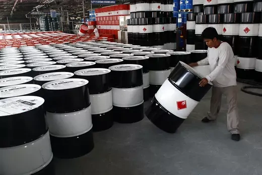 An employee of Petron Corp, the Philippines' largest oil refiner, prepares empty fuel drums.