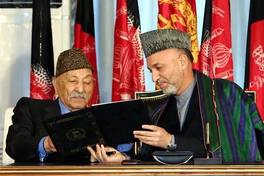 Afghan President Hamid Karzai shows the constitution to former king Zahir Shah.
