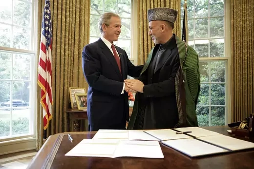 President Bush and President Karzai shaking hands in the Oval Office.
