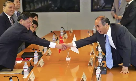 Former Chinese Foreign Ministry's Director of the Asian Affairs Department Hu Zhengyue shakes hands with Kenichiro Sasae, former head of the Foreign Ministry's Asian and Oceanian Affairs Bureau in 2007.