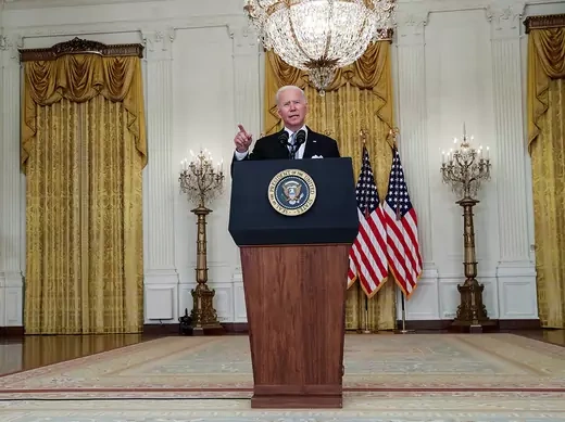 Joe Biden stands behind a podium in the White House.