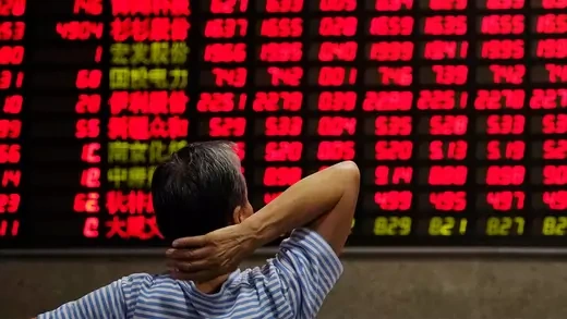 An investor looks at an electronic board showing stock information at a brokerage house in Shanghai, China September 7, 2018.