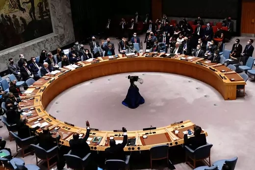 Members of the UN Security Council sit at a round table with a camera in the center.