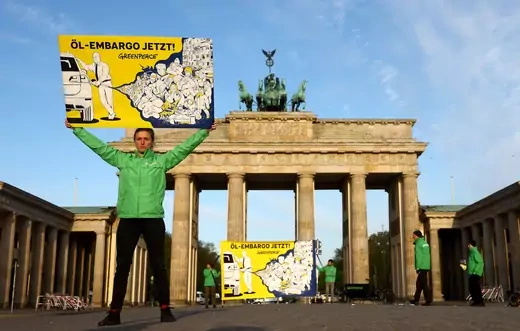 Greenpeace activists protest in front of the Brandenburg Gate in Berlin