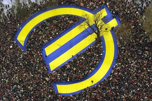 Thousands of people crowd around a huge euro symbol in Frankfurt's banking district on January 1, 1999, in celebration of the launch of the common currency. Axel Seidemann/AP