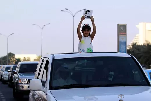 A girl holds a picture depicting Qatari Emir Sheikh Tamim bin Hamad al-Thani.