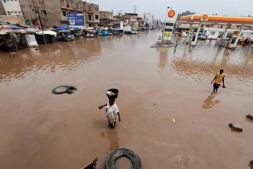 Residents make their way through a flooded street after heavy rains in Yoff, district of Dakar