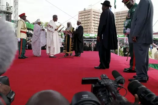 Nigeria's then incoming President Muhmmadu Buhari accepts his new role as Nigerian President as others look on. 