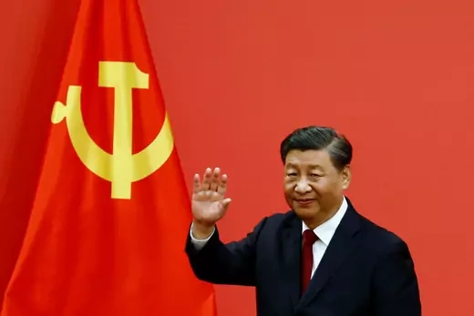Xi Jinping waves in front of the flag of the Communist Party of China