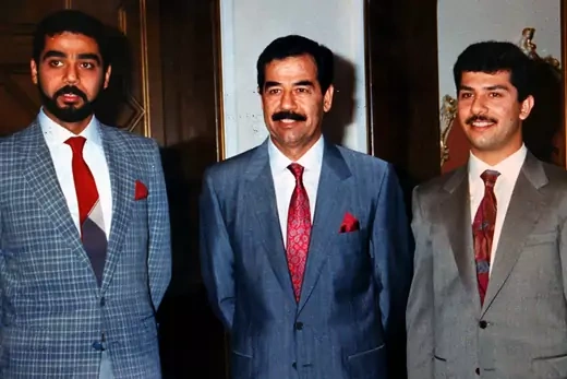 Saddam Hussein poses with his sons Uday and Qusay (R) in a photo from the private archive of an official photographer for the regime. 