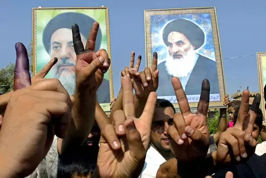 Iraqis show their ink-stained fingers and raise pictures of Grand Ayatollah Ali al-Sistani and late Mohammed Baqer al-Hakim as they jubilate in Baghdad's poor Sadr city neighborhood.