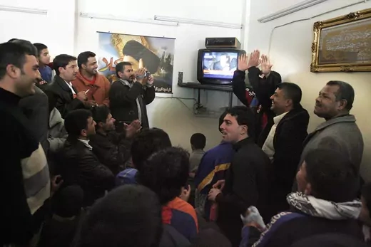 Iraqi Shiites cheer after hearing watching the official footage on TV of ousted Iraqi dictator Saddam Hussein's execution