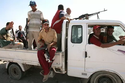 Former Iraqi insurgents, members of the Sunni Anbar Awakening, sit in the back of a pickup truck.