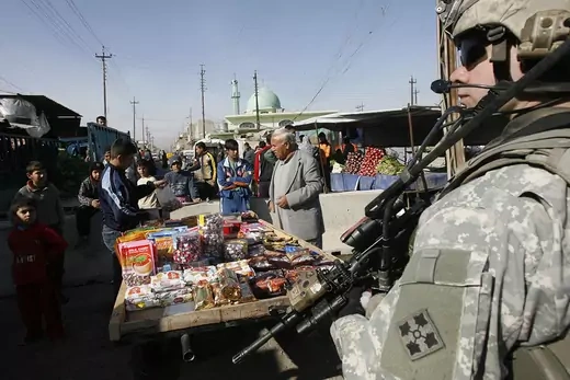 A U.S. soldier  stands guard in a street market in Mosul.