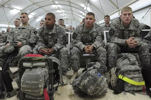U.S. soldiers listen to instructions as they wait for their flight back to the U.S. at Camp Virginia in Kuwait.
