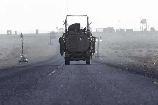 The last U.S. Army convoy vehicle drives down the road after crossing into Kuwait from Iraq.