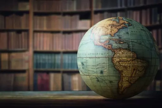 Old globe on bookshelf background. Selective focus. Retro style. Science, education, travel, vintage background.