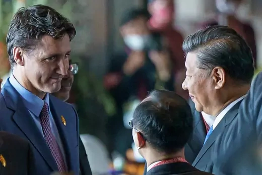 President Justin Trudeau of Canada faces President Xi Jinping of China as a translator interprets for them.