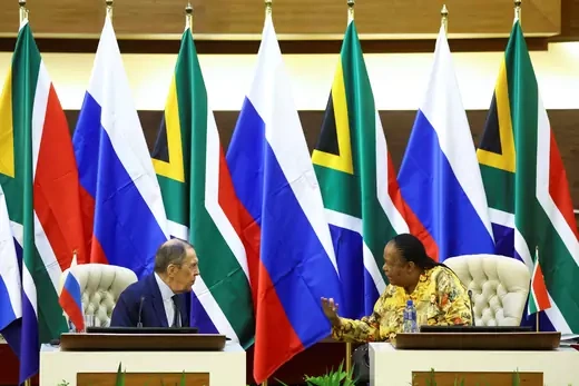 In front of a wall of South African and Russian flags, South Africa's Foreign Minister Naledi Pandor and Russian Foreign Minister Sergey Lavrov turn towards each other at a bilateral meeting in Pretoria, South Africa. 