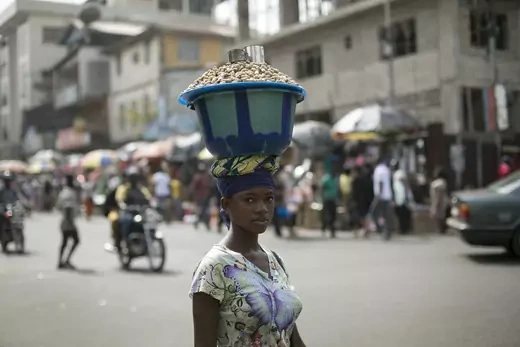 A Sierra Leonen woman carries a pot of peanuts on her head in Freetown, Sierra Leone, December 16, 2014.