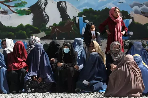 Afghan women wait to receive a food package being distributed by a Saudi Arabia humanitarian aid group at a distribution center in Kabul, Afghanistan, April 25, 2022.