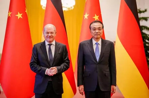 German Chancellor and Chinese Prime Minister stand beside each other in front of the German and Chinese flags.