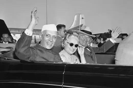 Prime Minister Jawaharlal Nehru of India, left, and Pres. Harry S. Truman, right, wave from an automobile.