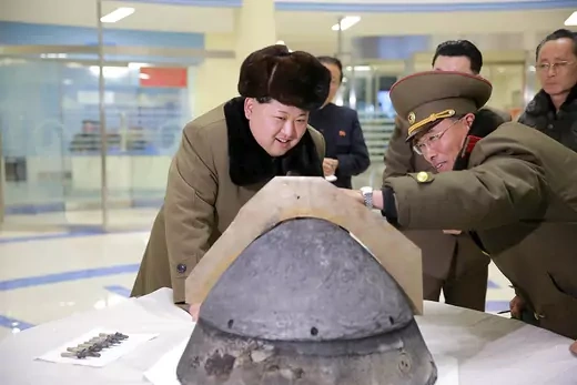 Kim Jong-un inspects the tip of a rocket warhead.
