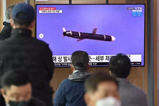 People watch a news broadcast showing file footage of a North Korean missile test in January 2022.