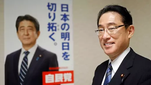 Kishida stands in front of Abe campaign poster