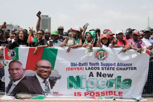 Youth supporters of Nigerian Presidential candidate Peter Obi hold a green, white, and red banner with the phrase, "A New Nigeria is Possible."