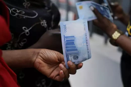 A person holds up a new 1000 Naira bank note in Nigeria. 