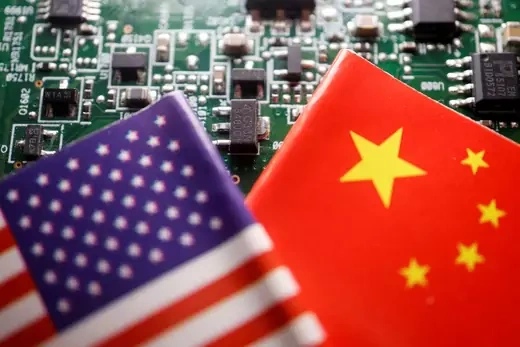 Flags of the United States and China are displayed on a printed circuit board with semiconductor chips in the background.
