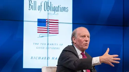Richard Haass speaks in front of screen showing cover of his new book