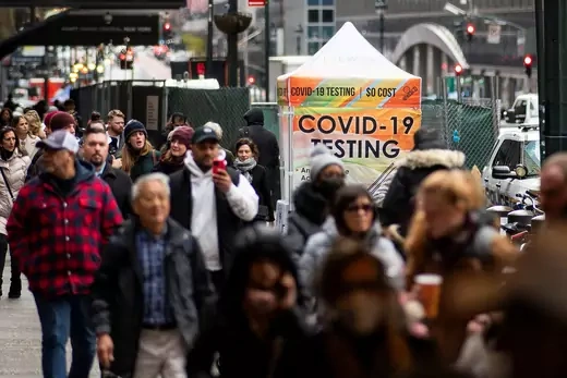 People walk next to a COVID-19 testing site in New York