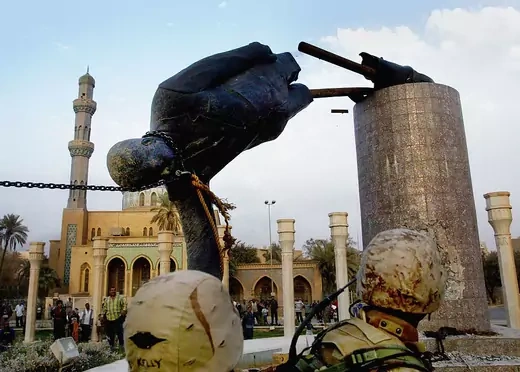 U.S marines and Iraqis are seen on April 9, 2003 as the statue of Iraqi dictator Saddam Hussein is toppled at al-Fardous square in Baghdad, Iraq.
